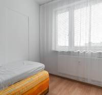 A bright room with a bed and a window with curtains in a 4-room apartment.