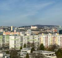 View of apartment buildings in Bratislava - Petržalka on Ševčenkova Street, with Bratislava Castle in the distance.