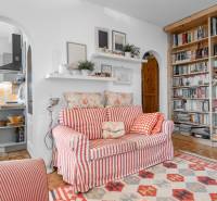Living room in a 4-room apartment with a patterned sofa, shelf, and bookcase.