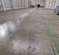 Spacious interior of warehouses and halls with concrete floor and packages on the left side.