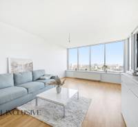 Living room with wood-patterned flooring, large windows, and a comfortable sofa in a two-room apartment.