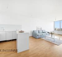 A cozy kitchen with white cabinets, a sofa, and a large glass wall in a 2-room apartment.