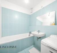 Bathroom in a 2-room apartment with blue tiles, a bathtub, and a washing machine.