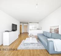 Living room with a blue sofa, white furniture, and a wood-patterned floor in a 2-room apartment.