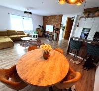 Living room in a family house with a sofa, dining table, and wooden decor flooring.