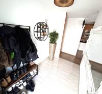 Interior of a family house with a coat rack, mirror, and wooden decor flooring.