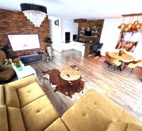 Living room with a sofa, dining table, and wooden decor flooring in a family house.