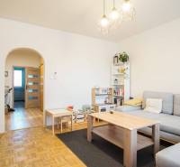 Living room in a three-room apartment with a wooden decor floor and light furniture.