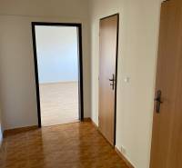 Interior of a 3-room apartment with a wooden decor floor and white walls.