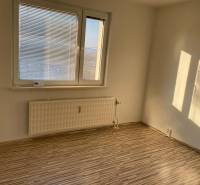 A room with a window, blinds, a radiator, and a floor with a wooden decor in a 3-room apartment.