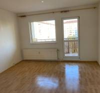 A room in a 3-room apartment with a wooden decor floor and access to a balcony.