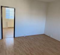 A room in a 3-room apartment with white walls and a wooden decor floor.