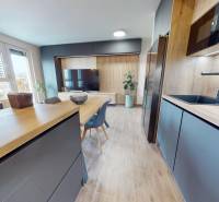 A kitchen in a 3-room apartment with a wooden decor floor and a dining table.