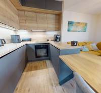 Kitchen in a 3-room apartment, light kitchen unit, floor with wood decor, yellow sofa.