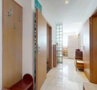 A bright hallway in a 4-room apartment with tiles and a wardrobe with colorful doors.