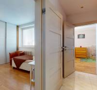 A hallway in a 4-room apartment with a wooden decor floor and built-in wardrobes.