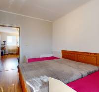 Bedroom in a 4-room apartment with a bed, wardrobe, and floor with a wooden decor.
