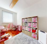 Children's room with tables, chairs, shelves, and a wooden decor floor in a 4-room apartment.
