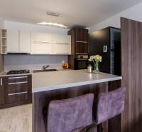 A kitchen in a 2-room apartment with a bar counter, a counter with a wooden decor floor, chairs.