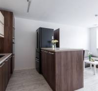 A kitchen in a 2-room apartment with a kitchen unit and a floor with a wooden decor.