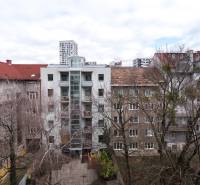 View of apartment buildings in Bratislava - Ružinov with front gardens and trees.