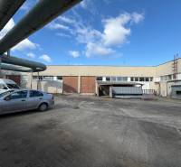 Warehouses and halls in Nové Zámky on the street Nové Zámky with an industrial complex and cars.