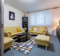 Living room with yellow sofas, a painting on the wall, and a patterned carpet in a 4-room apartment.