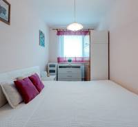 A bedroom with light furniture and decorative pillows in a 4-room apartment.