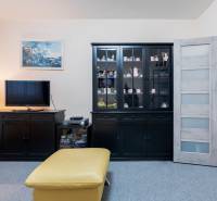 Living room in a 4-room apartment with dark furniture, a television, and a display cabinet.