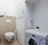 Bathroom with a toilet and a washing machine in a 4-room apartment, simple and practical.