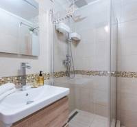 Bathroom in a 4-room apartment with a walk-in shower and a pedestal sink.