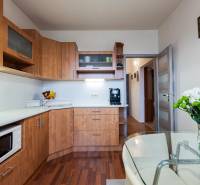 A kitchen with furnishings, flowers, and a floor with a wood decor in a 4-room apartment.