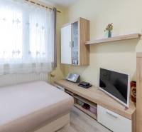 Interior of a 4-room apartment with a sofa, television, and furniture with a wooden decor.