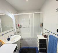 Bathroom in a 3-room apartment with a bathtub, sink, washing machine, and white tiles.