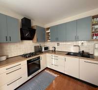 A kitchen in a 3-room apartment with a wooden decor floor and cooking equipment.