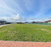 A view of a spacious building plot in Kočovce, surrounded by family houses.