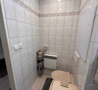 A bathroom in a 3-room apartment with a toilet, tiled with tiles and a trash can.