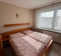 A bedroom in a 3-room apartment with wooden furniture and a floor with a wooden decor.