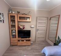 A room with a television, a mirror, a wooden set, and a sofa, in a 3-room apartment.