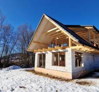 An unfinished cottage with a wooden roof during winter in Mýto pod Ďumbierom.