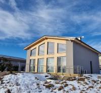 A cottage with large windows on a snowy hill in Dolná Lehota.