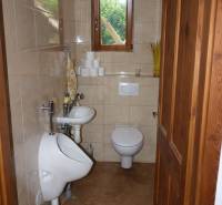 A small bathroom with a toilet, urinal, and sink in a three-room apartment.