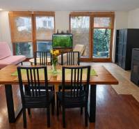 Dining room with balcony doors, an aquarium, and a table on a floor with a wood decor.