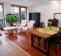 Living room in a three-room apartment with a wooden decor floor, a dining table, and an aquarium.