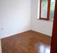 A room with wooden decor, white walls, a window, without furniture in a 3-room apartment.