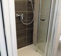 Shower enclosure with doors located in a studio apartment on Bodona Street.