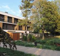 An apartment building on Bodona Street, surrounded by greenery and trees, ideal for studio living.