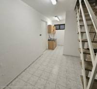 Interior with white walls, kitchen cabinet, staircase, and floor with wood decor.