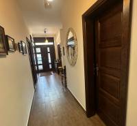 Hallway in a family house with a wooden decor floor and a decorative mirror on the wall.