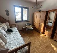 A room in a family house with a wooden decor floor and a bed.